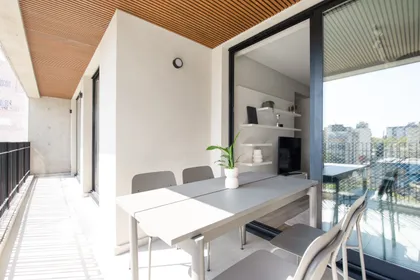 Balcón moderno con techo de madera y vista urbana — proyecto LOT Serrano, por C - ESTUDIO, en Buenos Aires